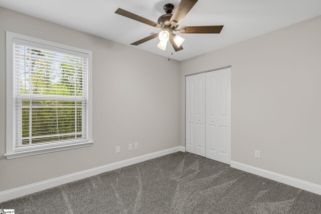 9 Amber Oaks Dr, Greer, SC 29651 - unfurnished bedroom with dark colored carpet, baseboards, a closet, and a ceiling fan