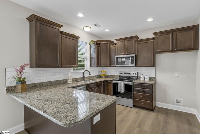 9 Amber Oaks Dr, Greer, SC 29651 - kitchen featuring stainless steel appliances, a sink, dark brown cabinets, a peninsula, and light stone countertops