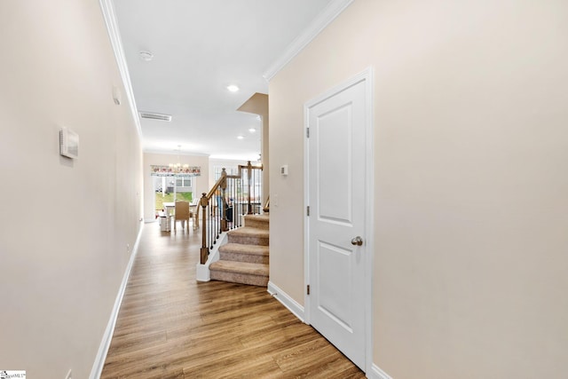 319 Sudduth Farms Dr, Greer, SC 29650 - hallway with a chandelier, ornamental molding, baseboards, light wood-style floors, and stairway