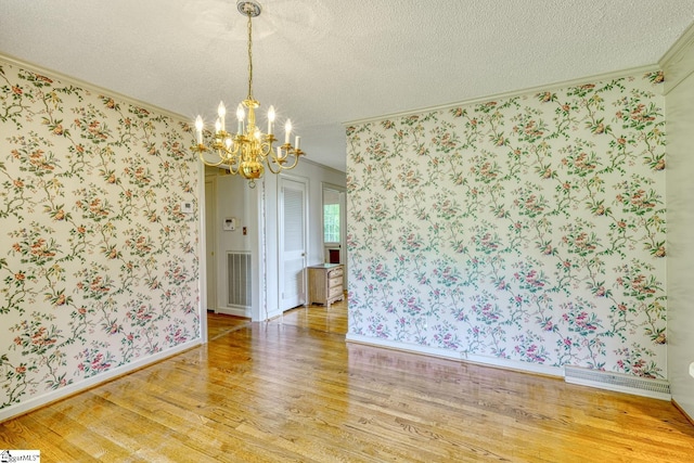 129 E Main St, Duncan, SC 29334 - unfurnished dining area featuring ornamental molding, light wood-style flooring, a chandelier, wallpapered walls, and a textured ceiling