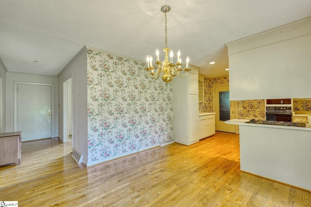 129 E Main St, Duncan, SC 29334 - unfurnished dining area with wallpapered walls, a textured ceiling, ornamental molding, light wood finished floors, and a chandelier