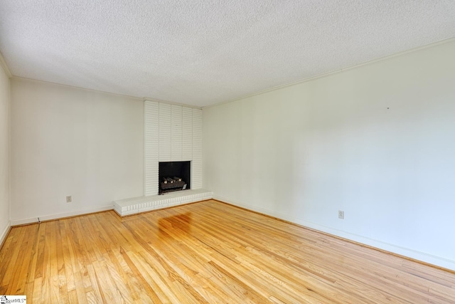 129 E Main St, Duncan, SC 29334 - unfurnished living room featuring wood finished floors, a textured ceiling, a fireplace, and baseboards