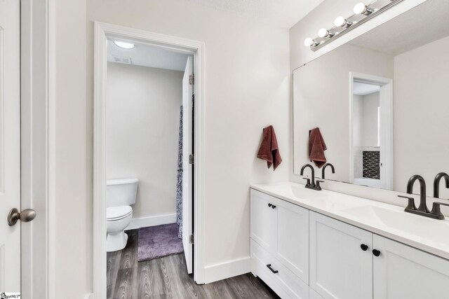 205 Glastonbury Dr, Greer, SC 29651 - bathroom with toilet, wood finished floors, baseboards, and double vanity