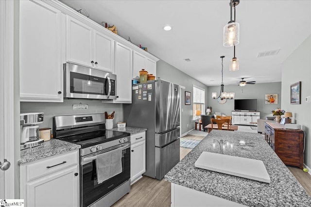 610 Circinae Rd, Cowpens, SC 29330 - kitchen with appliances with stainless steel finishes, light wood finished floors, white cabinets, and pendant lighting