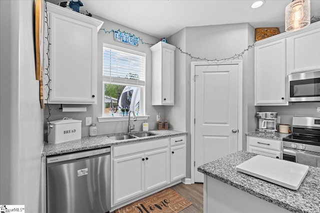 610 Circinae Rd, Cowpens, SC 29330 - kitchen with stainless steel appliances, a sink, white cabinets, and wood finished floors