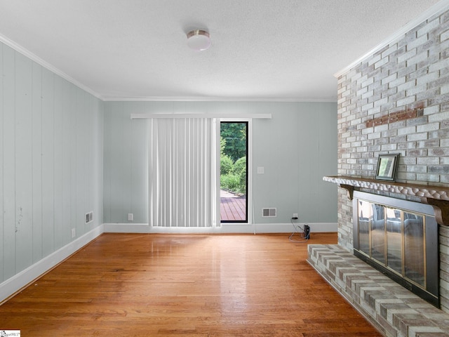221 N Hill Dr, Boiling Springs, SC 29316 - unfurnished living room featuring a brick fireplace, wood finished floors, ornamental molding, baseboards, and a textured ceiling