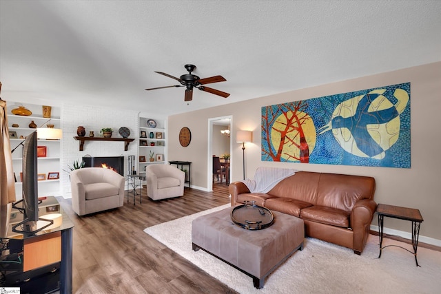 108 Hancock Ln, Greer, SC 29650 - living room featuring ceiling fan, baseboards, wood finished floors, a brick fireplace, and a textured ceiling