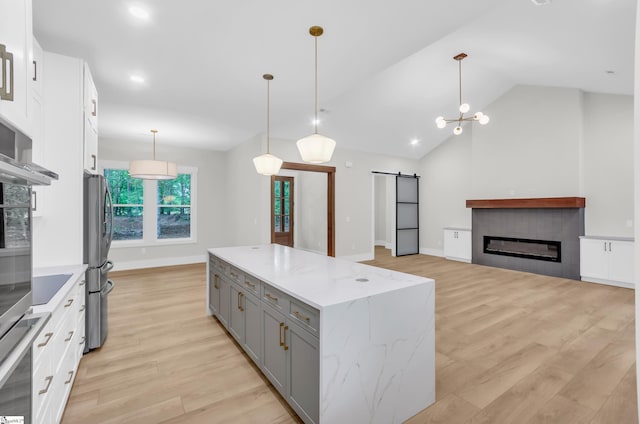 120 Thomason View Rd, Fountain Inn, SC 29644 - kitchen featuring gray cabinets, a barn door, light wood-type flooring, a kitchen island, and decorative light fixtures