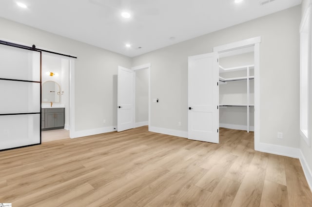 120 Thomason View Rd, Fountain Inn, SC 29644 - unfurnished bedroom featuring light wood-type flooring, a barn door, a walk in closet, baseboards, and recessed lighting