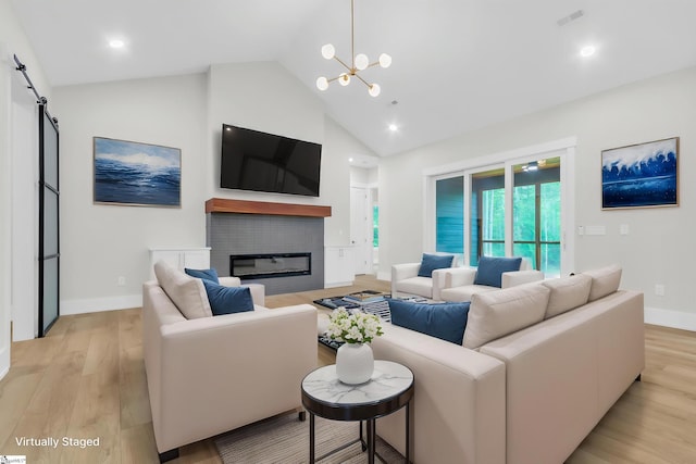 120 Thomason View Rd, Fountain Inn, SC 29644 - living area featuring high vaulted ceiling, light wood-style floors, a chandelier, a barn door, and a glass covered fireplace