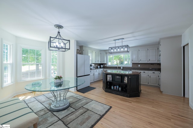 251 Williams Rd, Pelzer, SC 29669 - kitchen with freestanding refrigerator, dark countertops, a chandelier, light wood-style flooring, and a center island