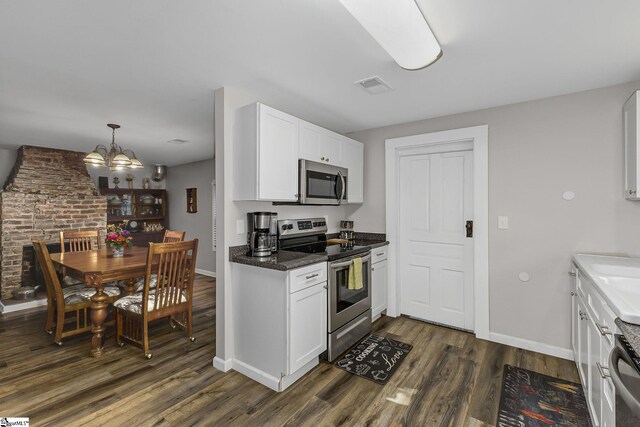 2444 Abner Creek Rd, Duncan, SC 29334 - kitchen with appliances with stainless steel finishes, dark wood finished floors, a chandelier, white cabinetry, and baseboards