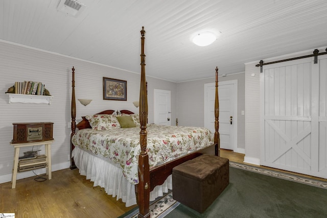2444 Abner Creek Rd, Duncan, SC 29334 - bedroom featuring a barn door, wood finished floors, and baseboards