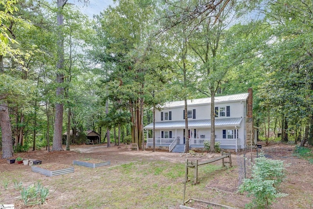 2444 Abner Creek Rd, Duncan, SC 29334 - rear view of property with a vegetable garden, covered porch, a chimney, metal roof, and view of wooded area