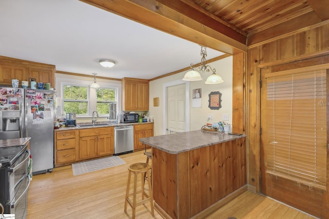 600 Gulliver St, Fountain Inn, SC 29644 - kitchen with stainless steel appliances, a sink, light wood-style flooring, a peninsula, and brown cabinetry