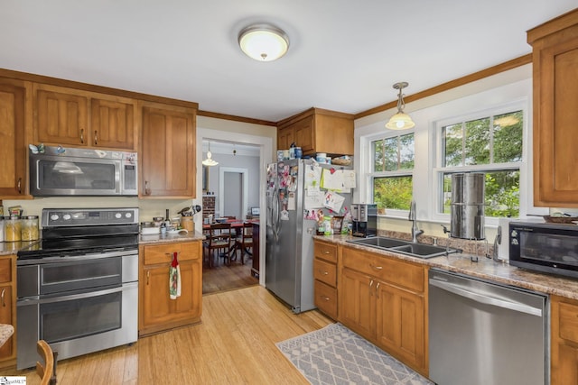 600 Gulliver St, Fountain Inn, SC 29644 - kitchen with stainless steel appliances, a sink, light wood finished floors, brown cabinets, and ornamental molding