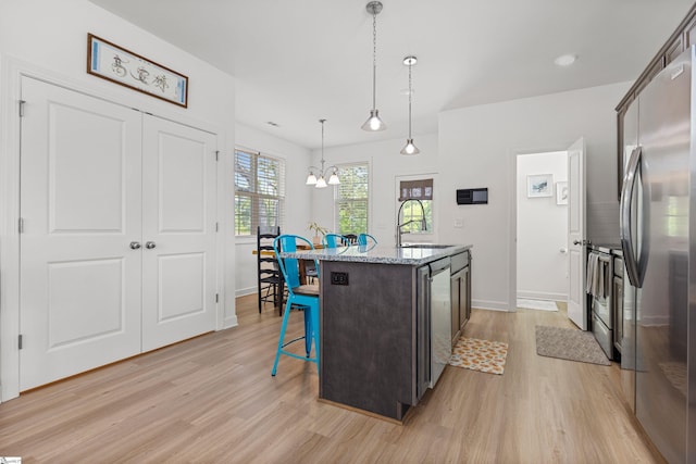 508 W D Ave, Easley, SC 29640 - kitchen with stainless steel appliances, a sink, light wood-style floors, a kitchen bar, and a chandelier