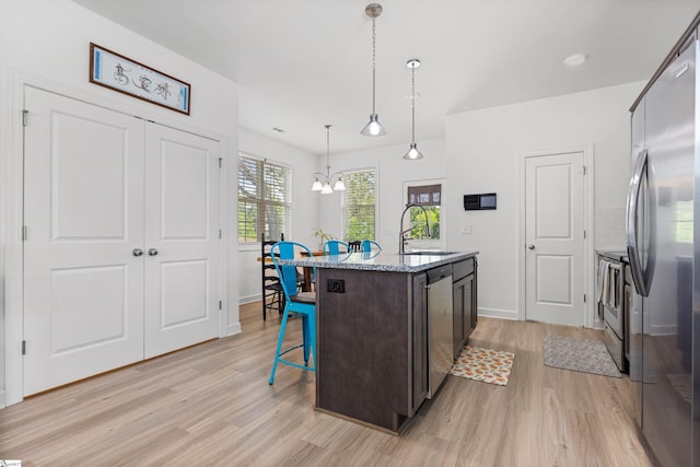 508 W D Ave, Easley, SC 29640 - kitchen with a sink, a breakfast bar, stainless steel appliances, light wood-style flooring, and dark brown cabinetry