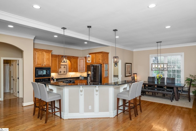 204 Whitworth Way, Simpsonville, SC 29681 - kitchen with black appliances, dark countertops, brown cabinets, light wood-type flooring, and a breakfast bar area