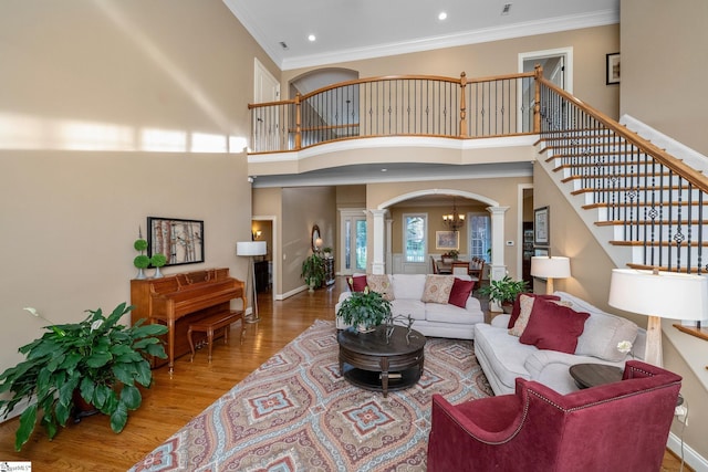 204 Whitworth Way, Simpsonville, SC 29681 - living room with ornate columns, arched walkways, wood finished floors, crown molding, and a towering ceiling