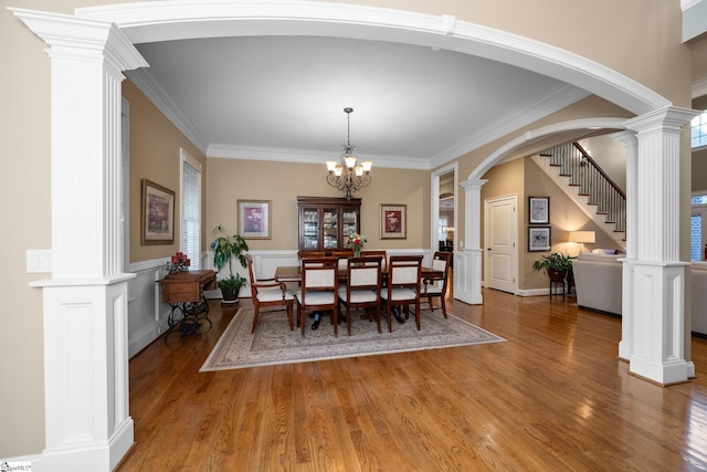 204 Whitworth Way, Simpsonville, SC 29681 - dining room featuring light wood-style flooring, arched walkways, crown molding, decorative columns, and a chandelier