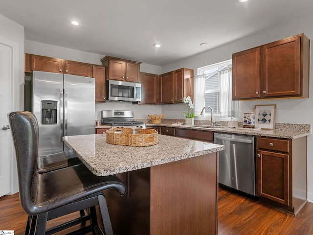 514 Olivia Springs Dr, Spartanburg, SC 29302 - kitchen featuring appliances with stainless steel finishes, a sink, dark wood-type flooring, a kitchen island, and a breakfast bar