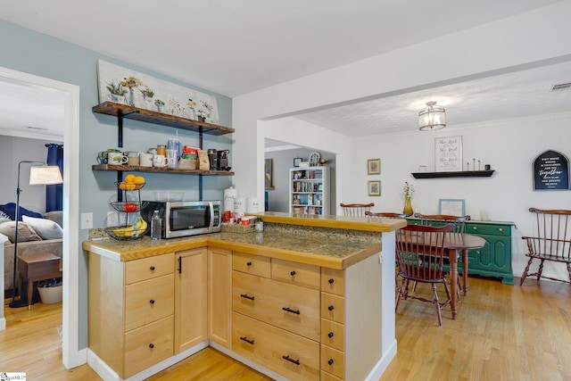 4600 Coach Hill Dr, Greenville, SC 29615 - kitchen featuring stainless steel microwave, light brown cabinets, light wood-style floors, tile countertops, and crown molding