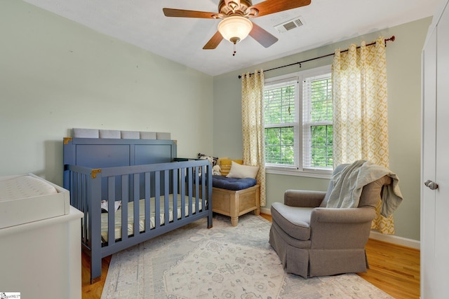 4600 Coach Hill Dr, Greenville, SC 29615 - bedroom featuring wood finished floors, baseboards, a crib, and a ceiling fan