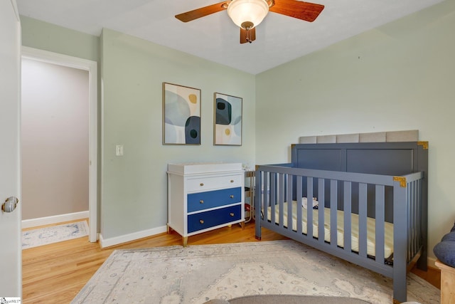 4600 Coach Hill Dr, Greenville, SC 29615 - bedroom featuring wood finished floors, baseboards, a crib, and a ceiling fan
