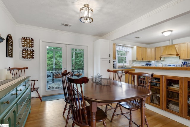 4600 Coach Hill Dr, Greenville, SC 29615 - dining room featuring light wood-type flooring, a textured ceiling, and ornamental molding