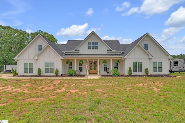 320 Terry Rd, Fountain Inn, SC 29644 - modern inspired farmhouse featuring board and batten siding, a front yard, covered porch, a standing seam roof, and french doors