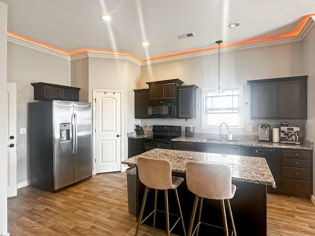 739 Shelburne Ln, Lyman, SC 29365 - kitchen with black appliances, a sink, ornamental molding, a breakfast bar area, and light stone countertops
