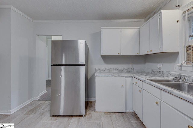 1709 Lyndon Ave, Anderson, SC 29624 - kitchen with freestanding refrigerator, a sink, white cabinets, light countertops, and wood finish floors