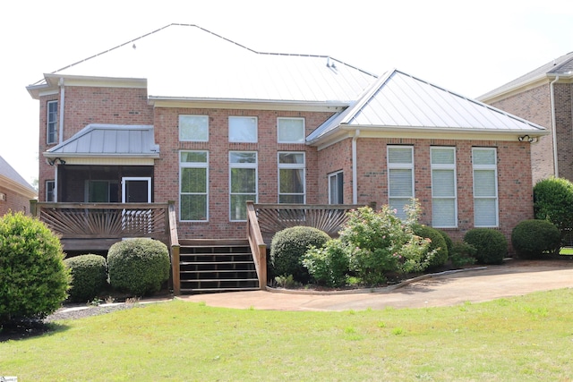 19 Ruby Lake Ln, Simpsonville, SC 29681 - rear view of house featuring a standing seam roof, brick siding, a deck, and a lawn