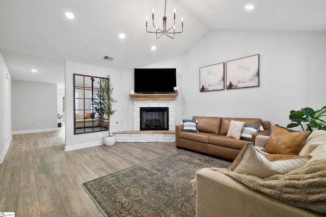 2606 Karkinnen Way, Moore, SC 29369 - living room with light wood-type flooring, lofted ceiling, a stone fireplace, baseboards, and a chandelier