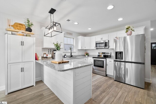 2606 Karkinnen Way, Moore, SC 29369 - kitchen with stainless steel appliances, a peninsula, light wood-style floors, white cabinetry, and a sink