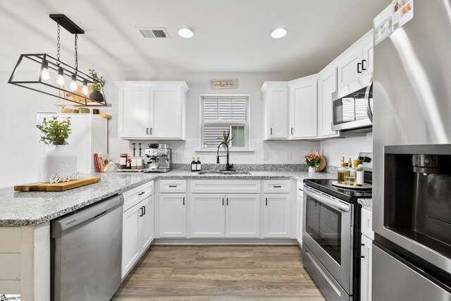 2606 Karkinnen Way, Moore, SC 29369 - kitchen featuring appliances with stainless steel finishes, a sink, a peninsula, white cabinets, and recessed lighting