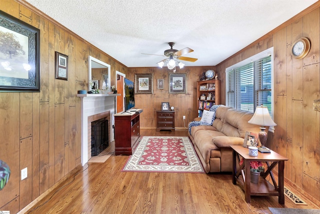 3040 Sunset Forest Rd, Anderson, SC 29626 - living area with wood walls, wood finished floors, a brick fireplace, ceiling fan, and a textured ceiling