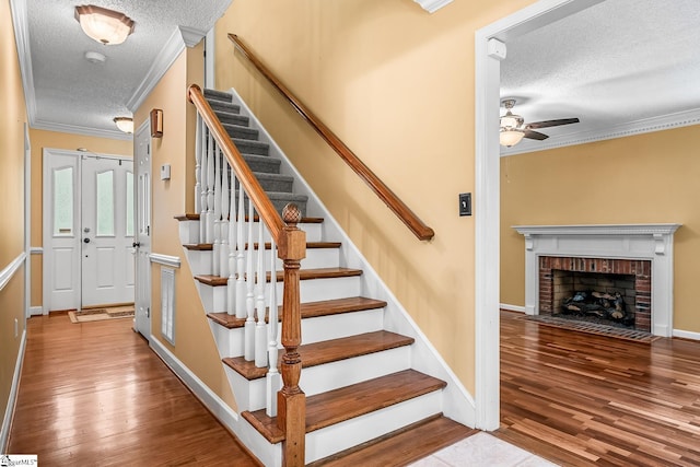 103 Farming Creek Dr, Simpsonville, SC 29680 - stairway with a textured ceiling, ornamental molding, wood finished floors, ceiling fan, and a fireplace