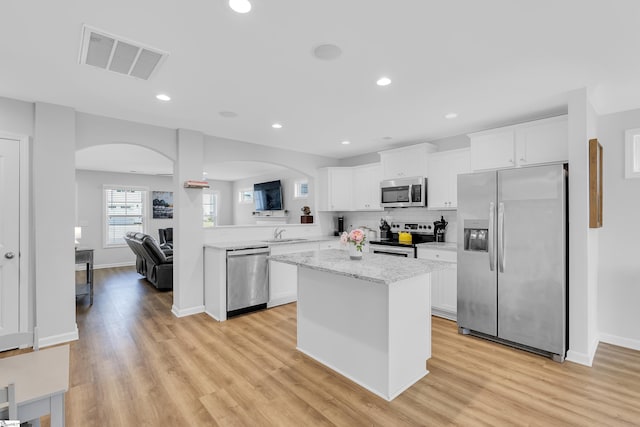 116 Bruinen Dr, Fountain Inn, SC 29644 - kitchen featuring appliances with stainless steel finishes, arched walkways, white cabinetry, a kitchen island, and recessed lighting