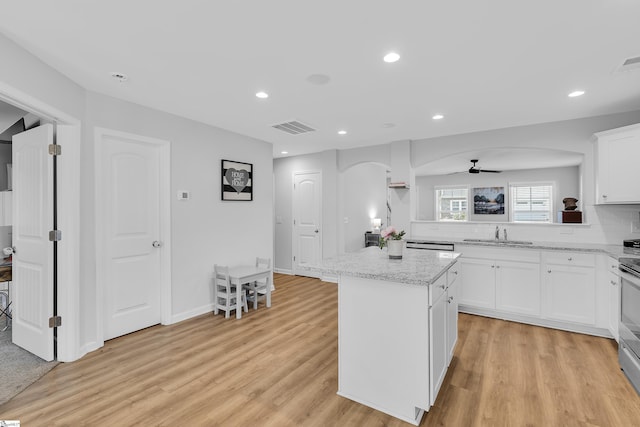 116 Bruinen Dr, Fountain Inn, SC 29644 - kitchen with arched walkways, a sink, a center island, a ceiling fan, and light wood-style floors