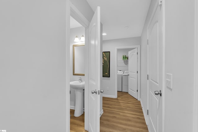 116 Bruinen Dr, Fountain Inn, SC 29644 - corridor featuring washer and dryer, light wood-style floors, baseboards, and a sink