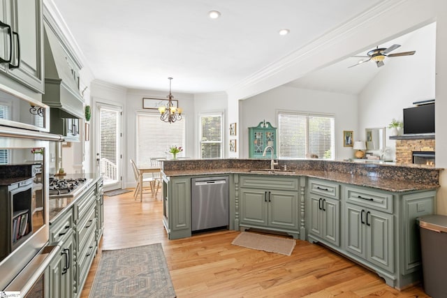 1 Riverstone Way, Greer, SC 29651 - kitchen featuring a stone fireplace, stainless steel appliances, a sink, a chandelier, and light wood-style floors