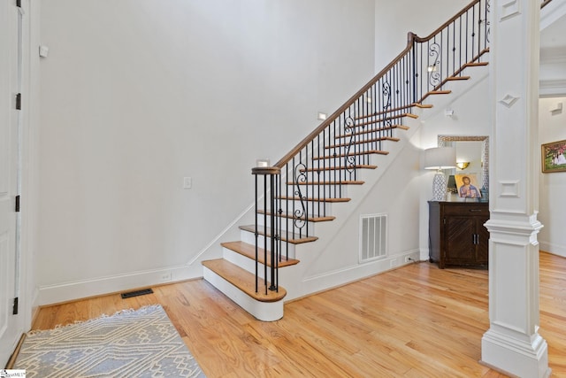 1 Riverstone Way, Greer, SC 29651 - staircase featuring wood finished floors, decorative columns, baseboards, and a high ceiling