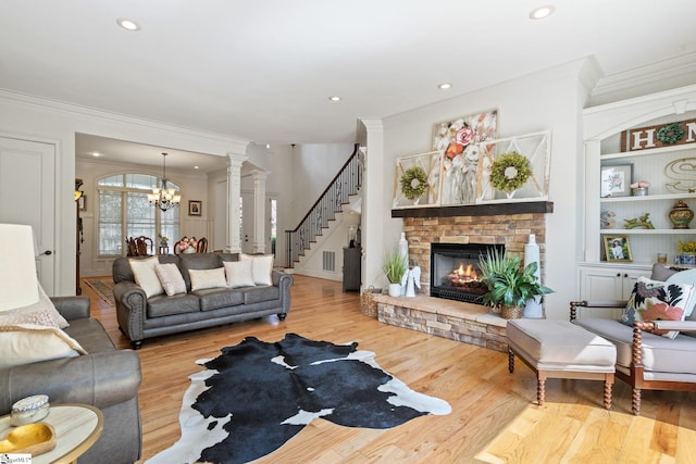 1 Riverstone Way, Greer, SC 29651 - living room with a chandelier, ornamental molding, a stone fireplace, wood finished floors, and stairs