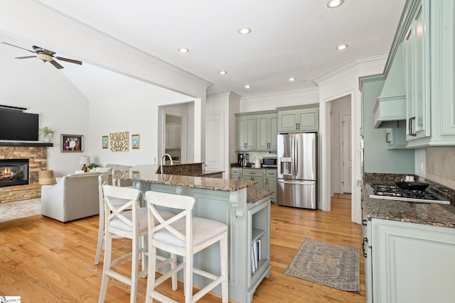 1 Riverstone Way, Greer, SC 29651 - kitchen featuring stainless steel appliances, open floor plan, ceiling fan, a breakfast bar, and a stone fireplace