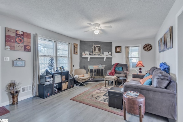 273 Cedar Springs Rd, Spartanburg, SC 29302 - living area featuring plenty of natural light, ceiling fan, wood finished floors, a textured ceiling, and a brick fireplace