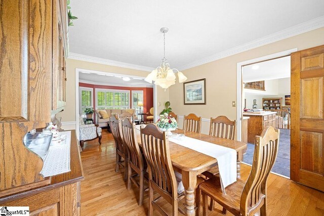 3 Staten Ln, Taylors, SC 29687 - dining area with light wood finished floors, crown molding, and a chandelier