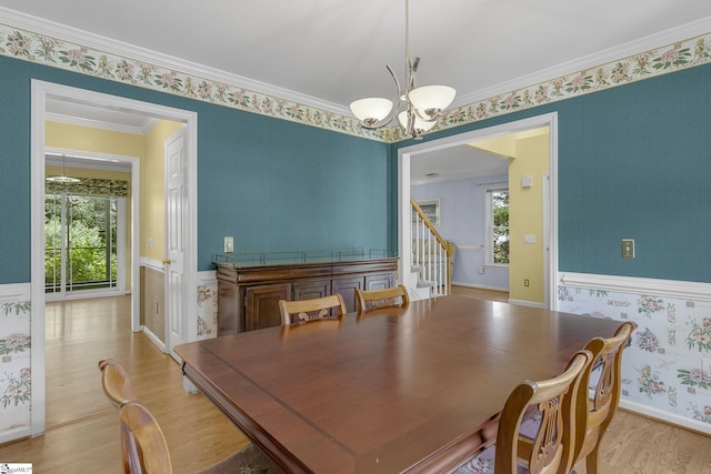 411 Wild Horse Creek Dr, Simpsonville, SC 29680 - dining space with a chandelier, light wood finished floors, stairs, wallpapered walls, and a wainscoted wall
