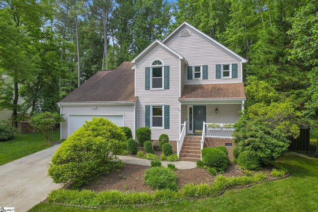 411 Wild Horse Creek Dr, Simpsonville, SC 29680 - traditional home featuring covered porch, a shingled roof, an attached garage, driveway, and a front lawn